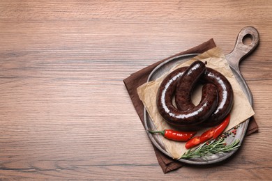 Photo of Tasty blood sausages served on wooden, top view. Space for text