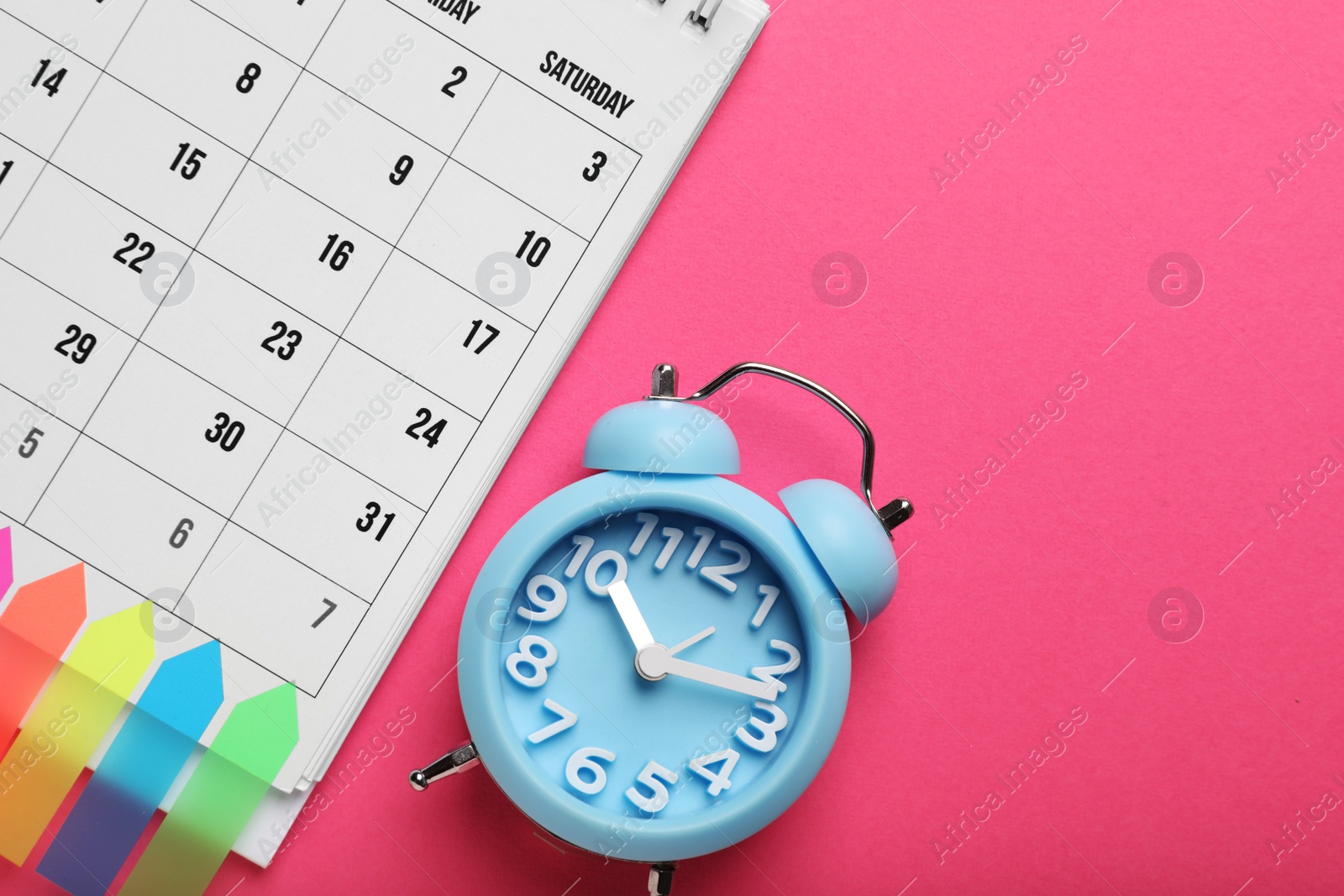 Photo of Alarm clock and calendar on pink background, flat lay with space for text. Reminder concept