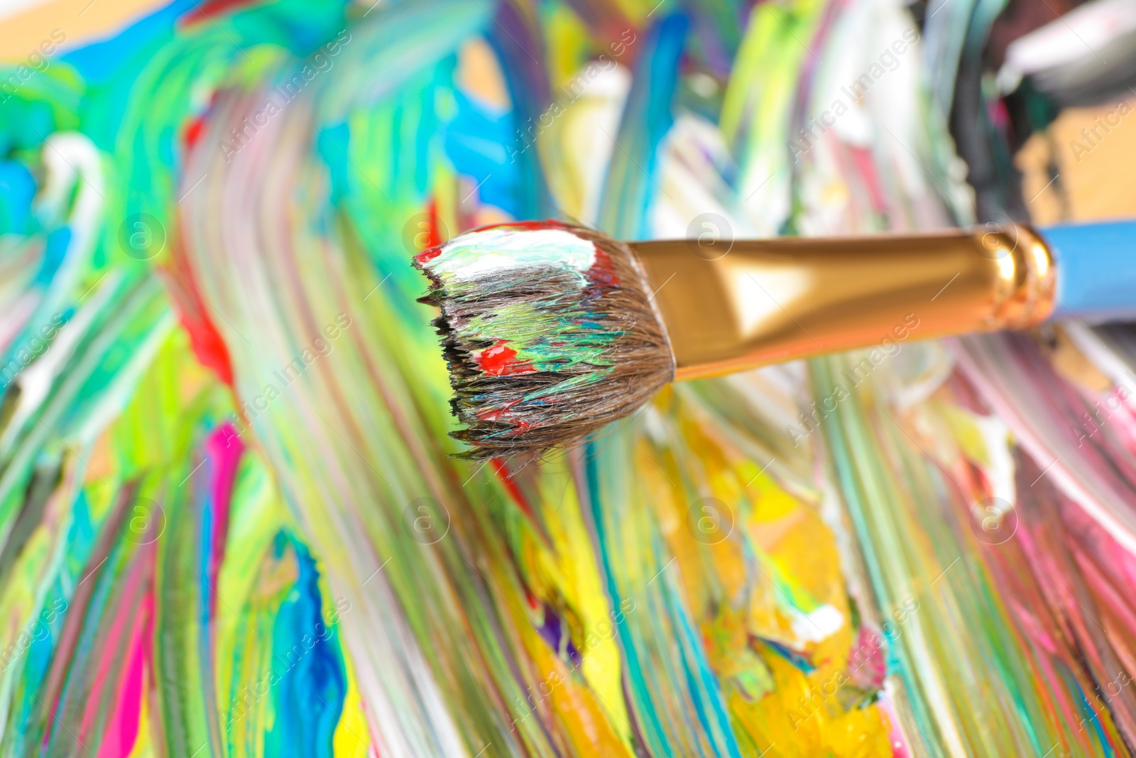 Photo of Abstract colorful acrylic paint and brush, closeup view