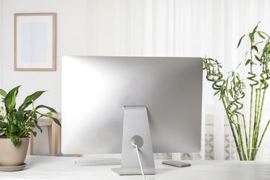 Office interior with houseplants and computer monitor on table