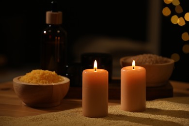 Photo of Spa composition with burning candles and personal care products on soft light surface