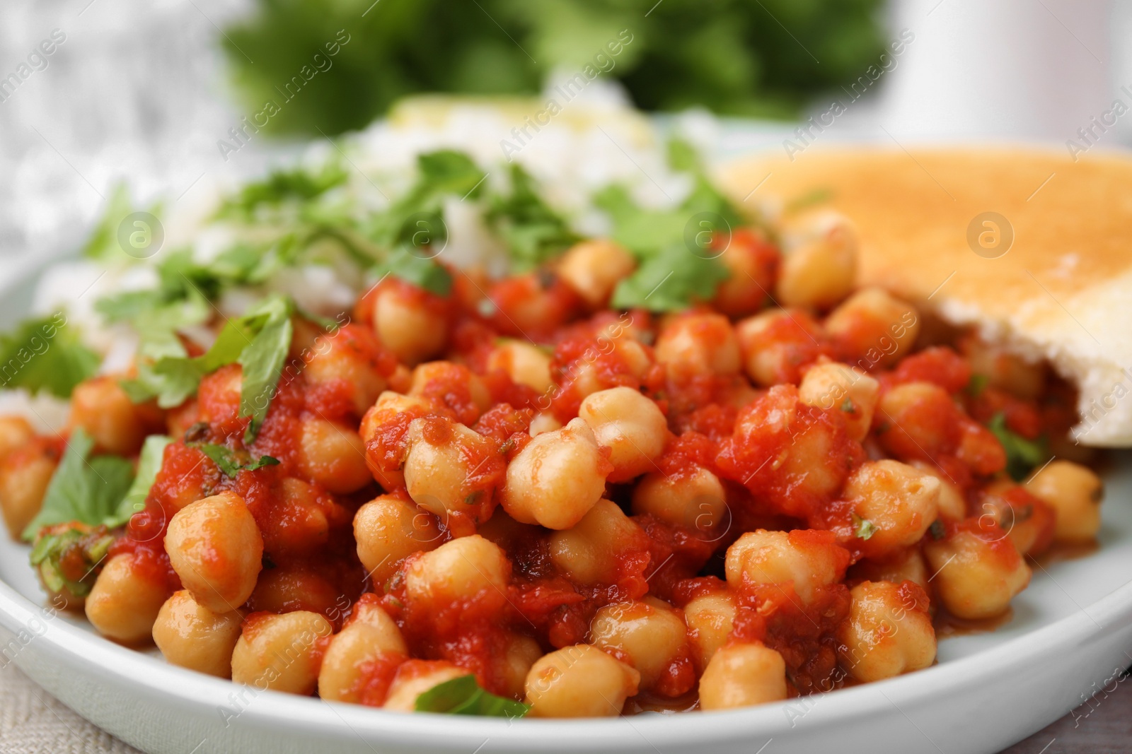 Photo of Plate with delicious chickpea curry on table, closeup