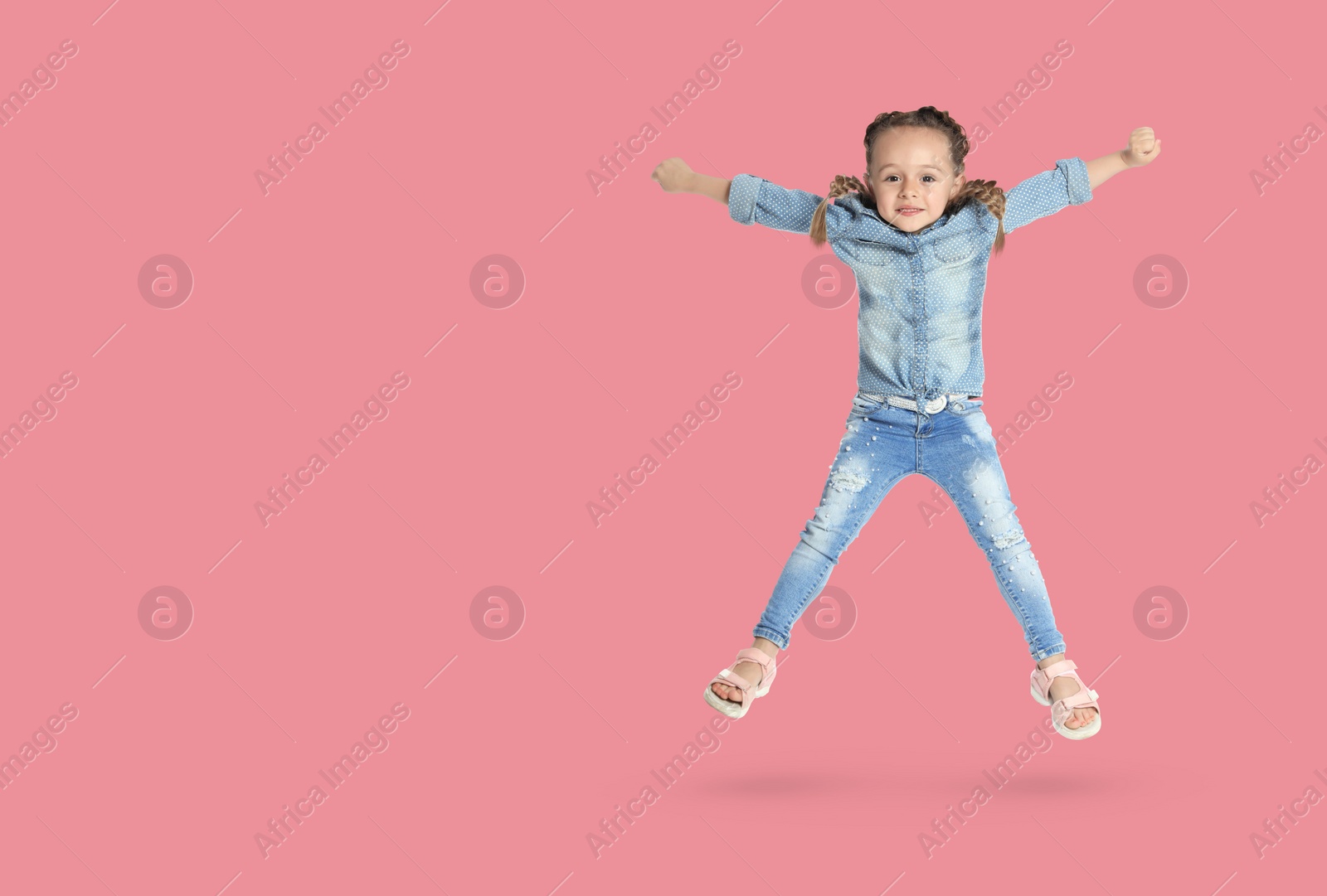 Image of Cute girl jumping on pink background, space for text