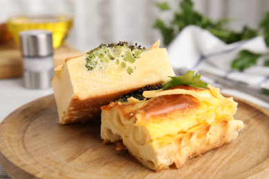 Photo of Tasty broccoli casserole on wooden board, closeup