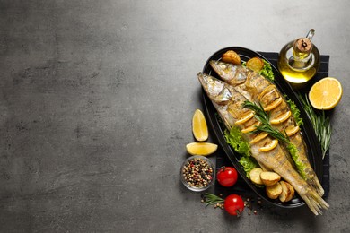 Photo of Tasty homemade roasted pike perches served on grey table, flat lay and space for text. River fish