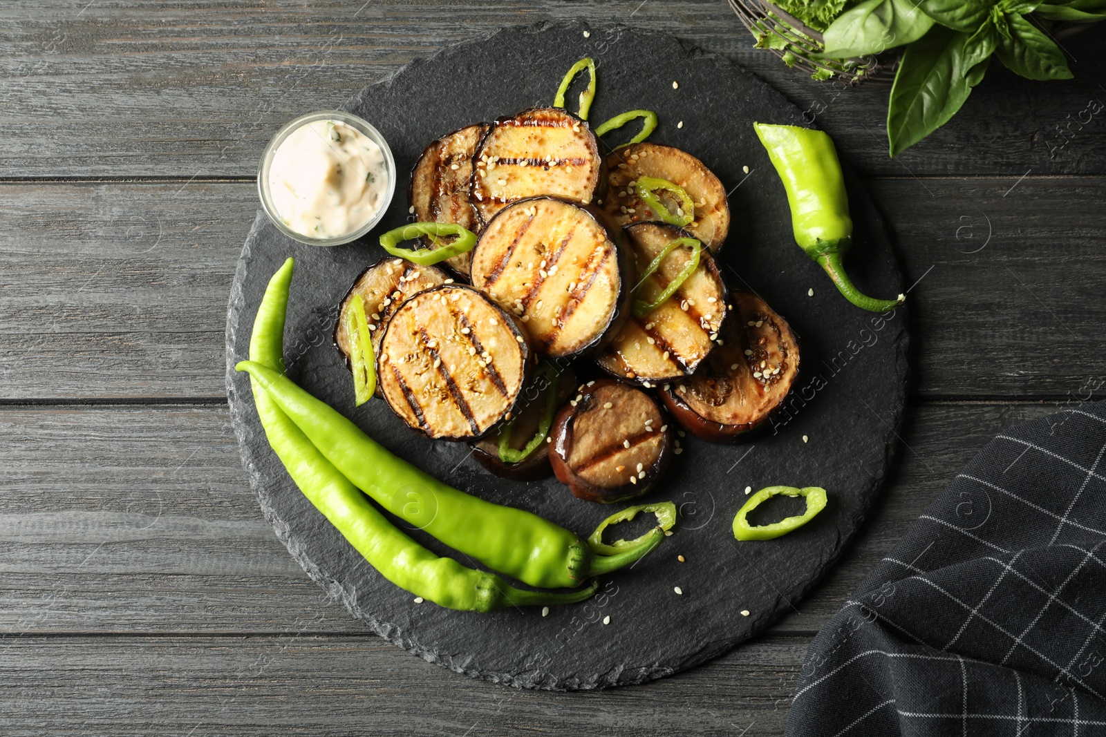 Photo of Slate plate with fried eggplant slices on wooden table, top view