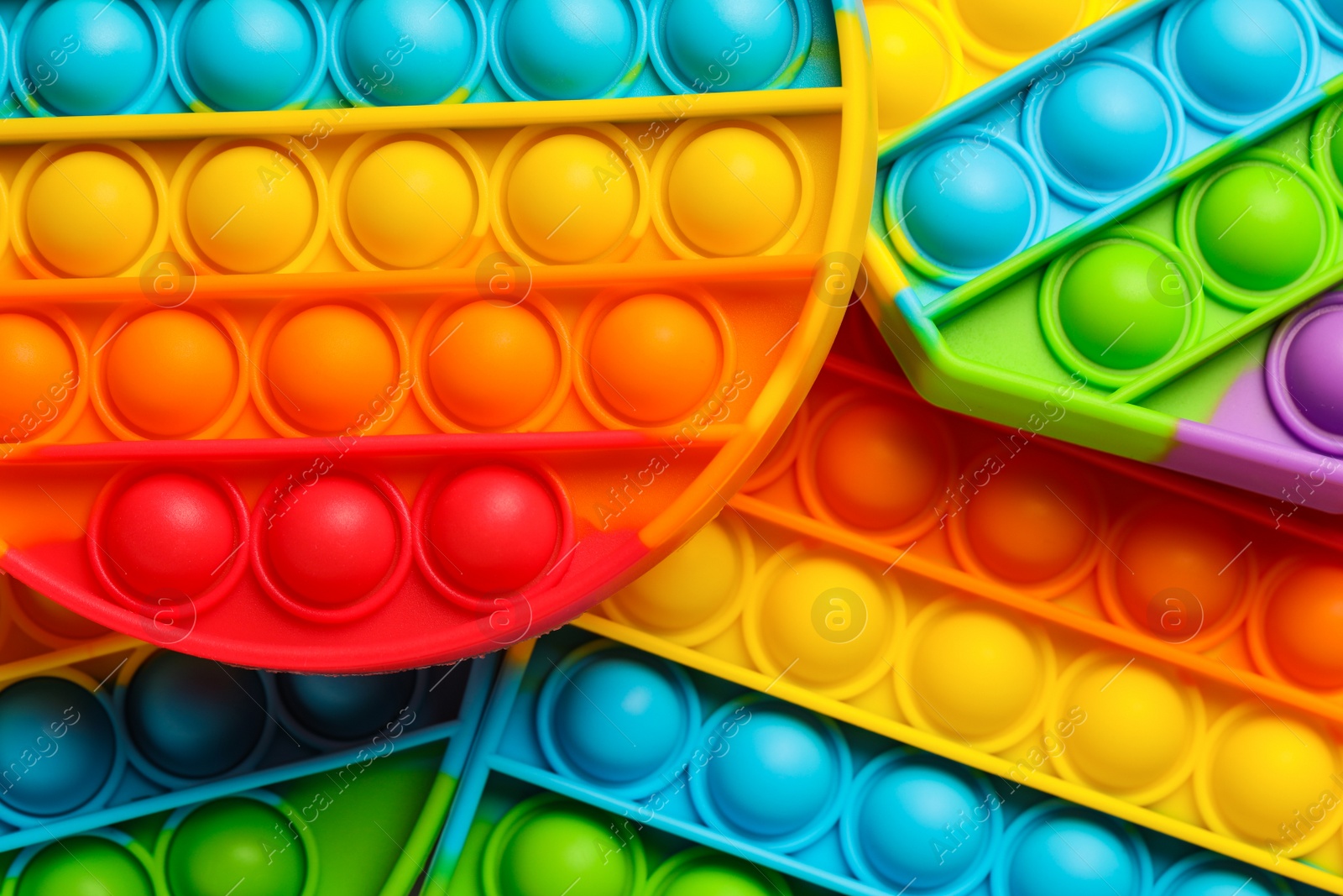 Photo of Rainbow pop it fidget toys as background, closeup