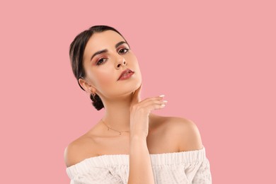 Beautiful woman with elegant jewelry on pink background