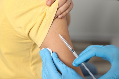 Photo of Doctor giving injection to patient in hospital, closeup. Vaccination day