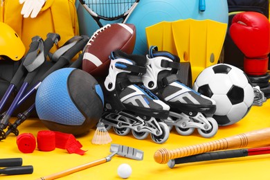 Many different sports equipment on yellow background