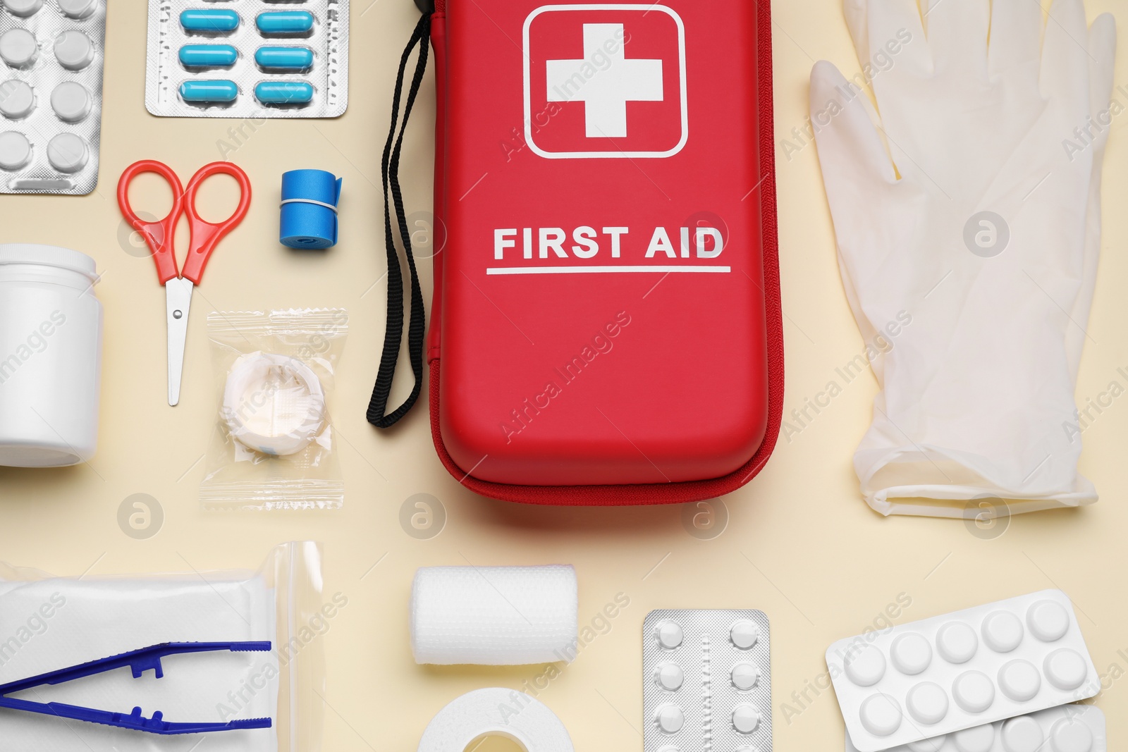 Photo of Flat lay composition with first aid kit on beige background