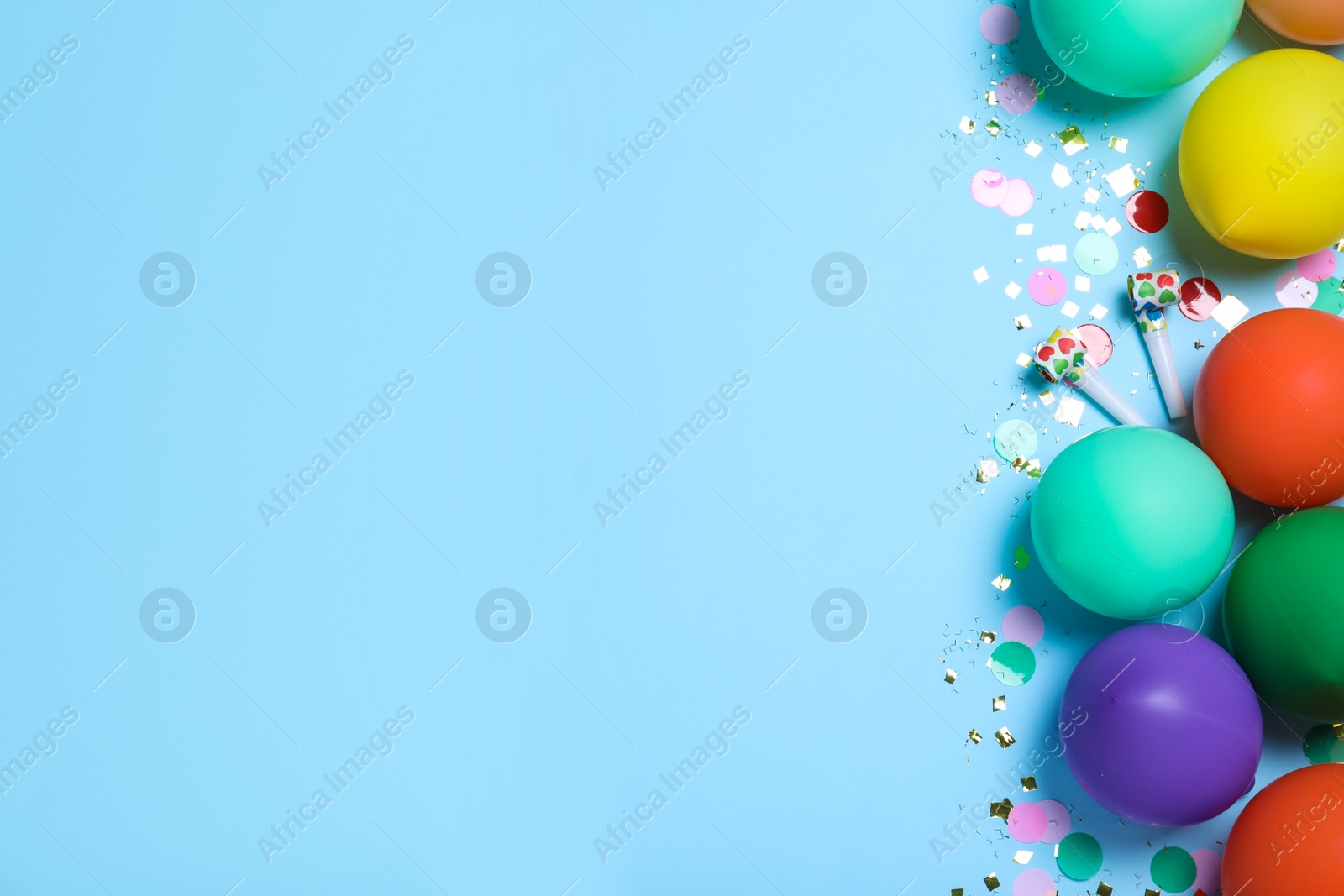 Photo of Flat lay composition with balloons and confetti on light blue background, space for text. Birthday decor