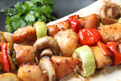 Delicious shish kebabs with vegetables on plate, closeup