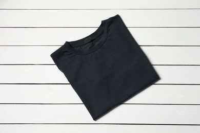 Photo of Stylish black T-shirt on white wooden table, top view