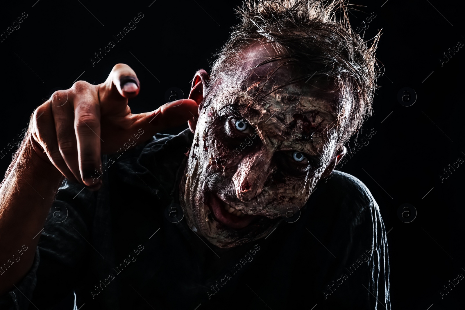 Photo of Scary zombie on dark background. Halloween monster