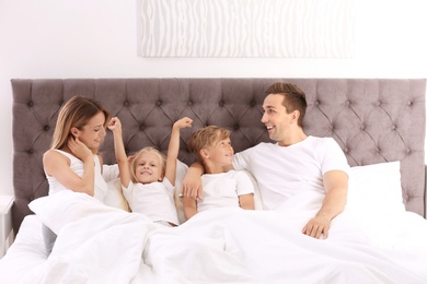 Photo of Happy family in bed with pillows at home. Weekend morning