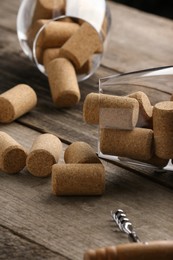 Photo of Glasses with wine corks and corkscrew on wooden table