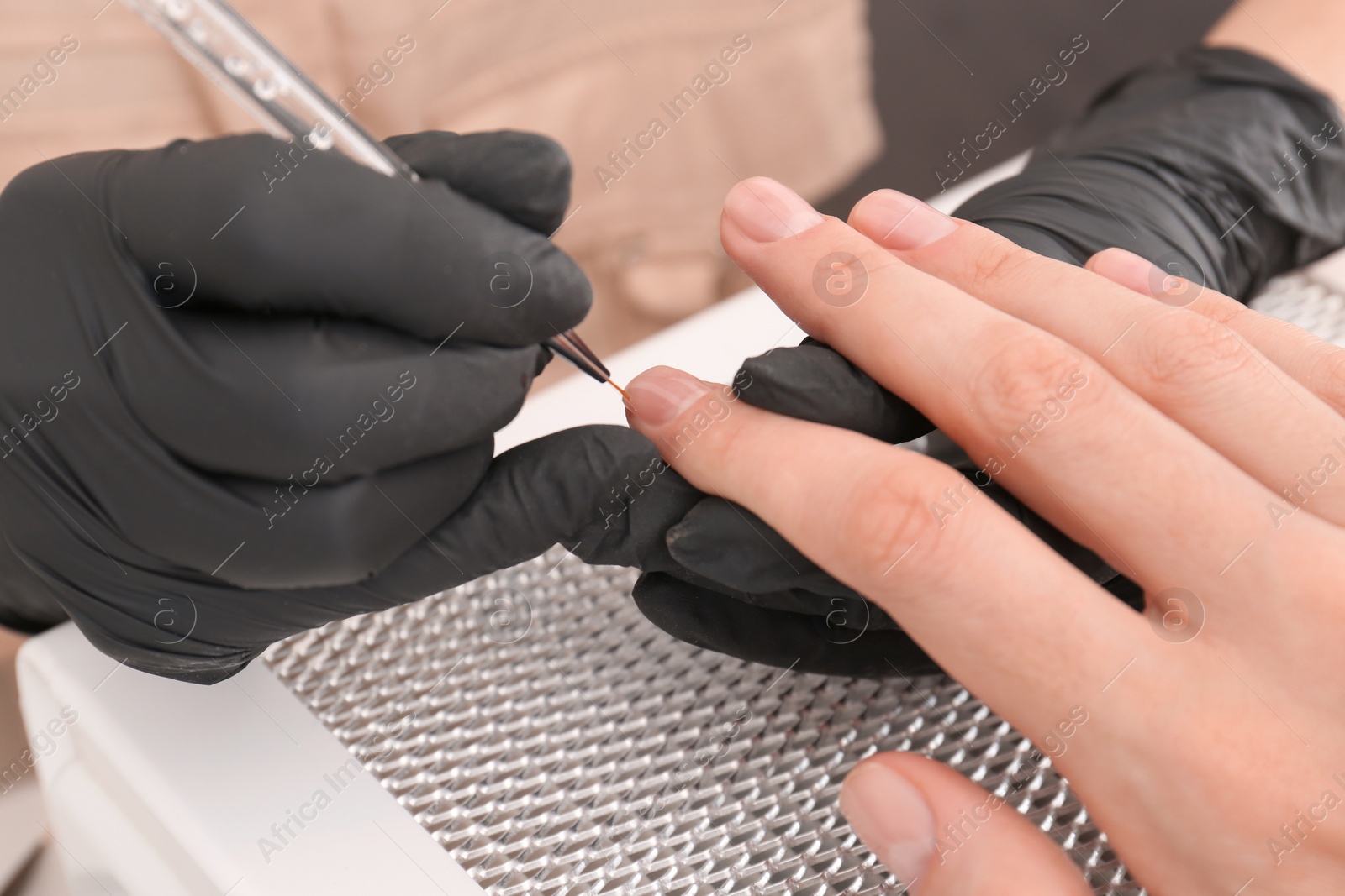 Photo of Professional manicurist working with client, closeup view