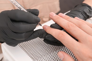 Photo of Professional manicurist working with client, closeup view