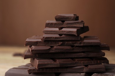 Pieces of tasty chocolate on blurred background, closeup
