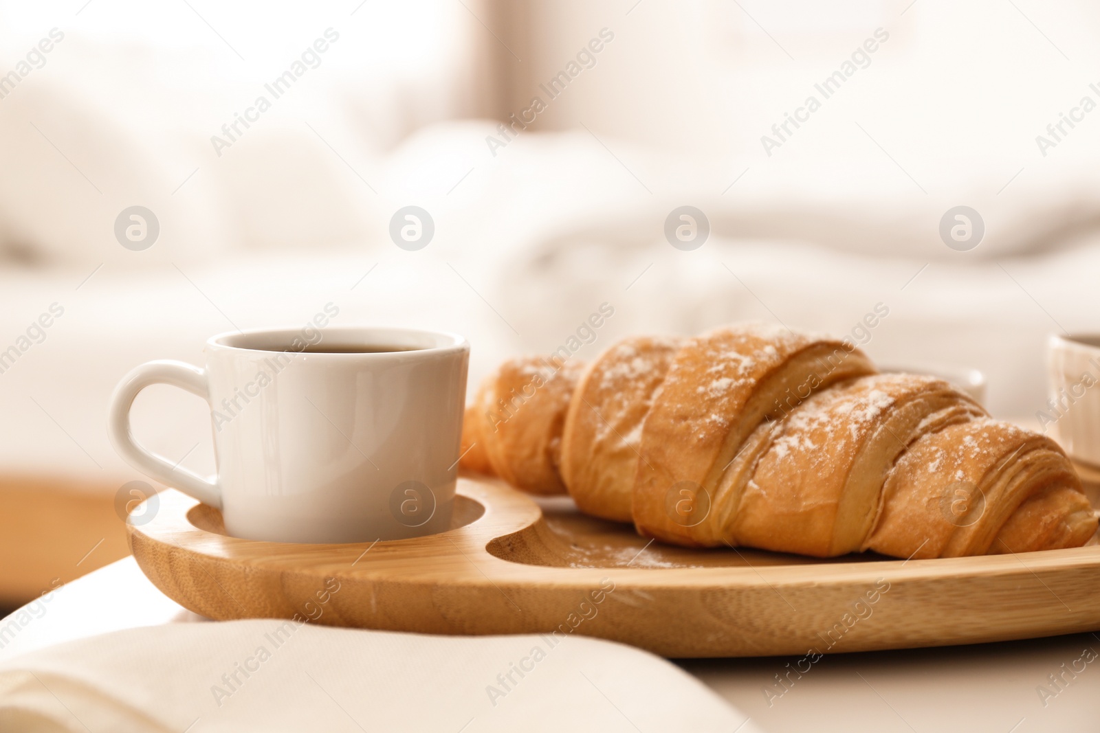 Photo of Delicious morning coffee and croissant on table indoors