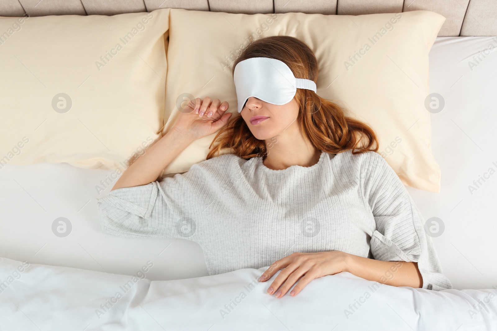 Photo of Woman with sleep mask in bed, top view