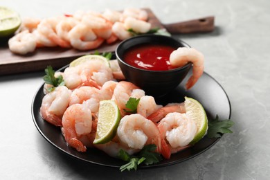 Photo of Tasty boiled shrimps with cocktail sauce, parsley and lime on light grey table