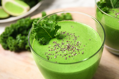 Photo of Tasty kale smoothie with chia seeds on wooden table, closeup