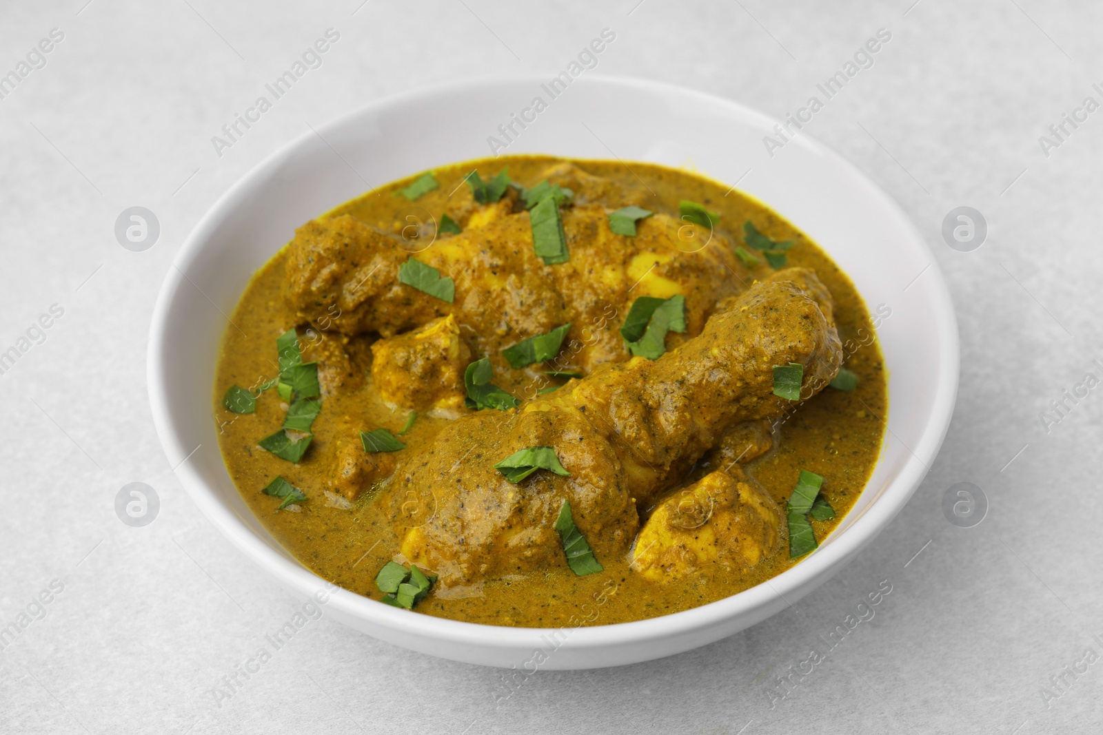 Photo of Delicious chicken with curry sauce on white table