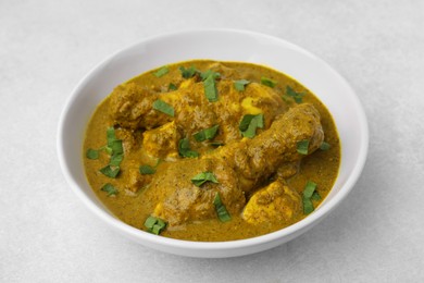 Delicious chicken with curry sauce on white table