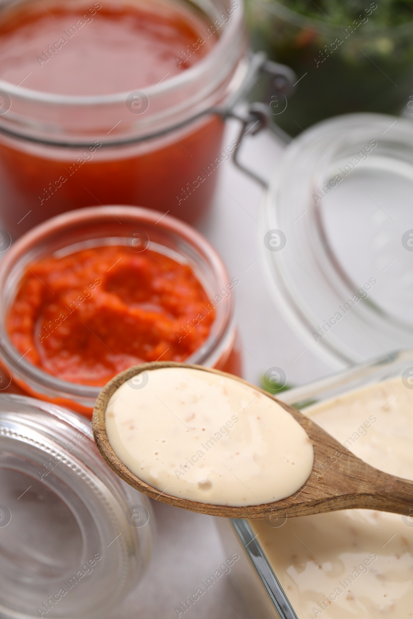 Photo of Spoon with fresh marinade over table, closeup