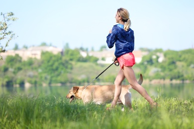 Young woman and her dog spending time together outdoors. Pet care