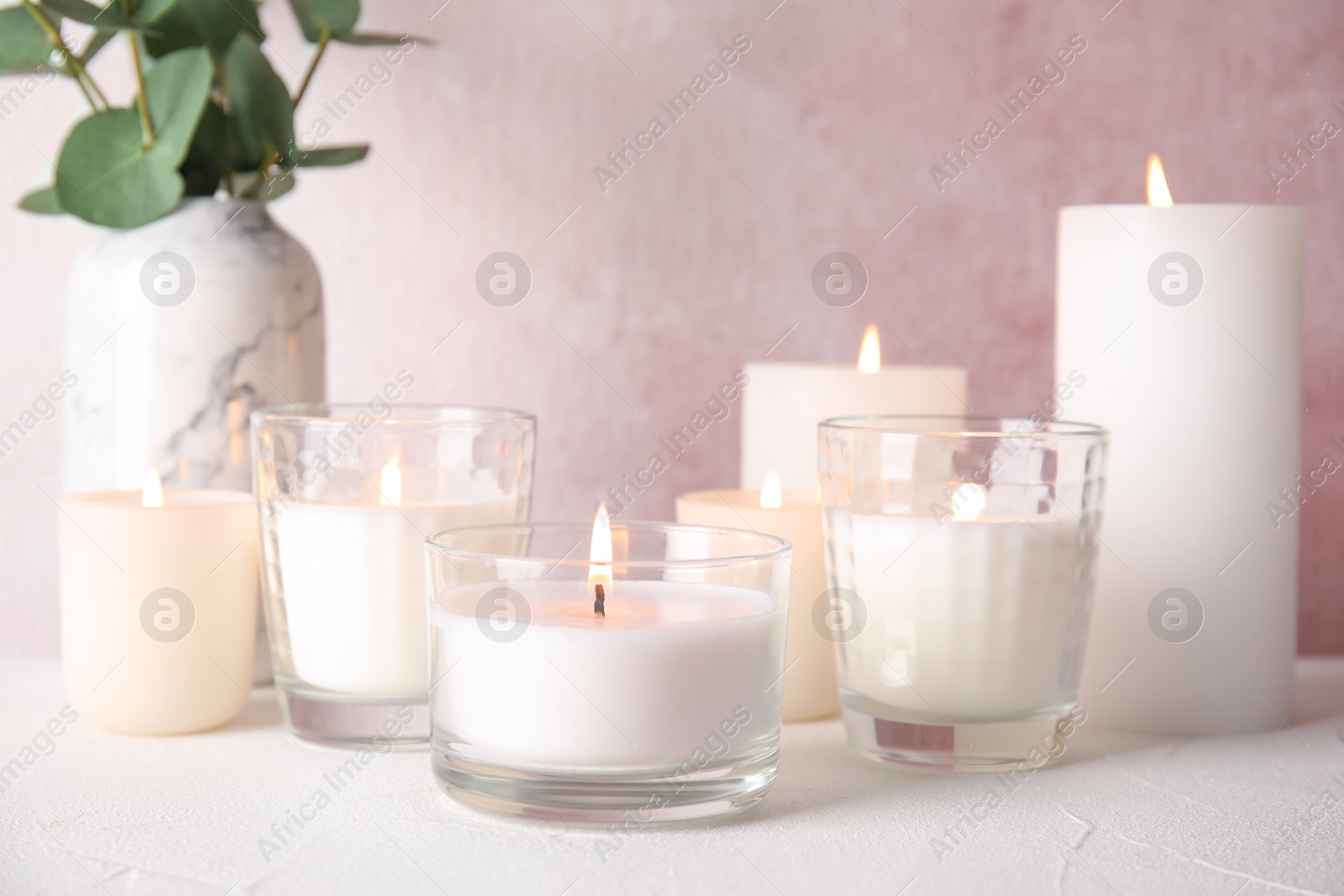 Photo of Burning aromatic candles in holders on table