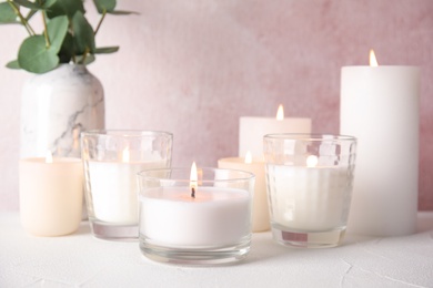 Burning aromatic candles in holders on table