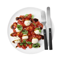 Photo of Tasty salad Caprese with tomatoes, mozzarella balls, basil and cutlery on white background, top view
