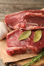 Pieces of raw beef meat and spices on table, closeup