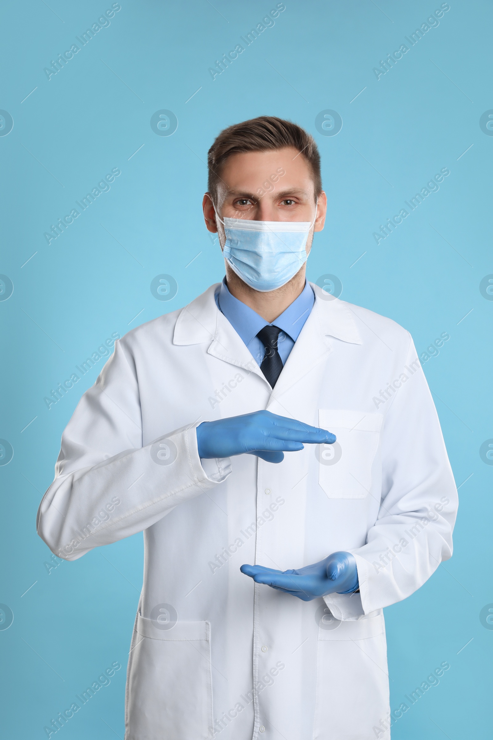 Photo of Dentist holding something on light blue background