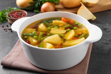 Photo of Bowl of delicious turnip soup on grey table