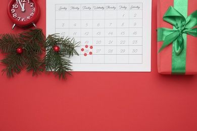 Flat lay composition with calendar and alarm clock on red background, space for text. Boxing Day