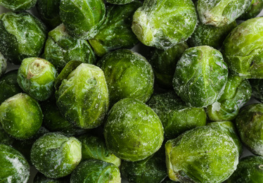 Photo of Frozen Brussels sprouts as background, top view. Vegetable preservation