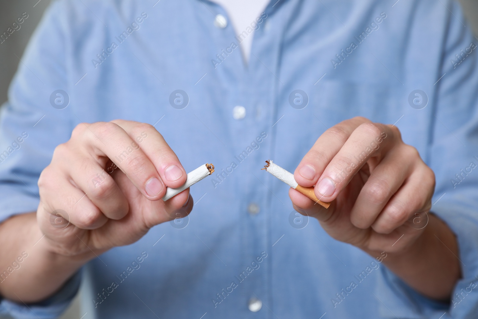 Photo of Stop smoking concept. Man holding pieces of broken cigarette, closeup