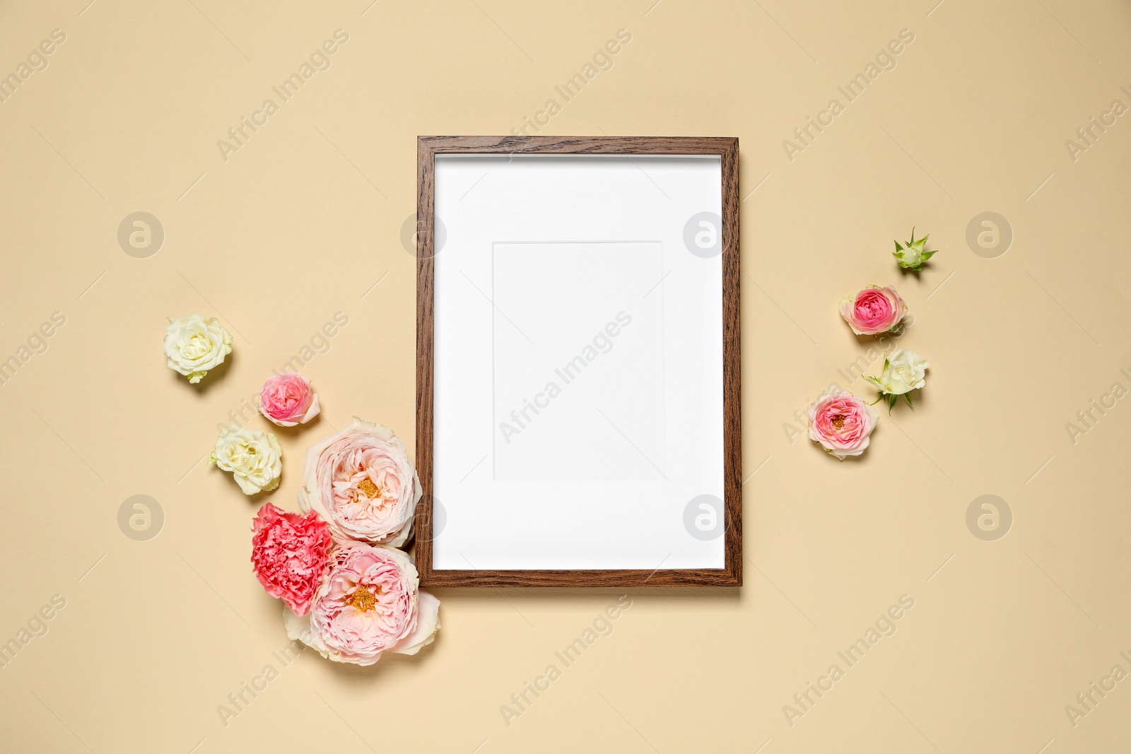 Photo of Empty photo frame and beautiful flowers on beige background, flat lay. Space for design