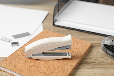 Photo of Stapler, notebook and papers on wooden table