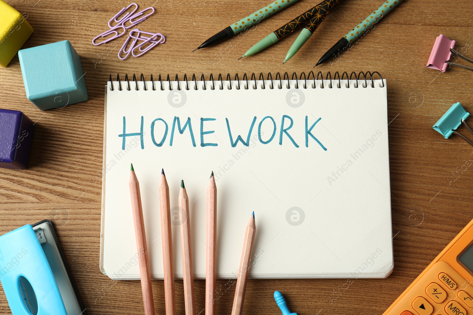 Photo of Flat lay composition of notebook with word HOMEWORK on wooden table