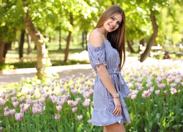 Photo of Beautiful young woman in green park on sunny spring day