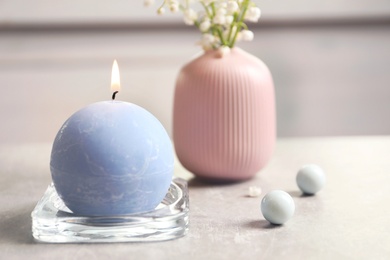 Beautiful composition with burning candle and flowers on table