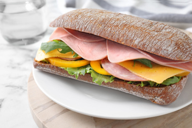 Photo of Tasty sandwich with ham on table, closeup