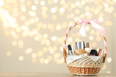 Wicker basket with cosmetics as present against blurred festive lights. Space for text