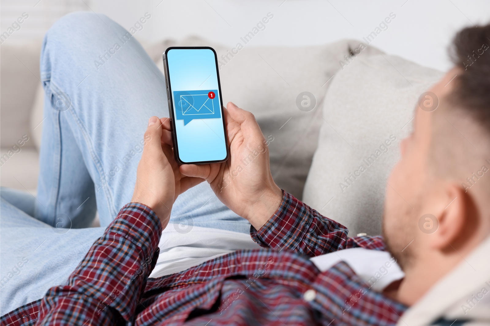 Image of New message notification. Man with mobile phone indoors, closeup