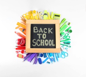 Photo of Chalkboard with phrase "BACK TO SCHOOL" and different stationery on white background, top view